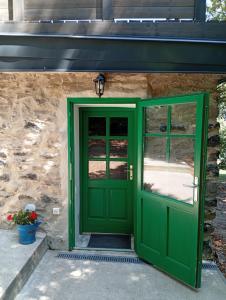 a green door in front of a stone building at Kaán Károly Kulcsosház in Kisapáti
