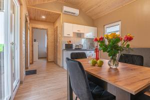 a kitchen and dining room with a wooden table and flowers at DOMKI#ENERGY Zator in Przeciszów