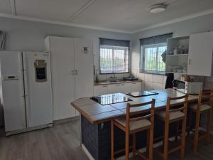 a kitchen with a refrigerator and a table and chairs at Silver’s Rest Beach House in Clareport