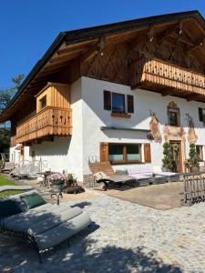a large house with a wooden roof and a patio at Chalet Apart Hansler in Ehrwald