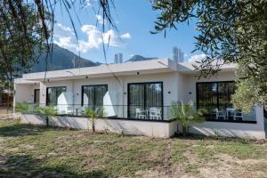 a white house with tables and chairs in front of it at Marea Suites Borsh in Borsh