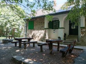 a group of picnic benches in front of a building at Kaán Károly Kulcsosház in Kisapáti