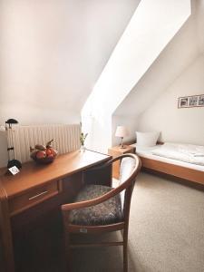 a room with a desk and a bed and a chair at Pension Zur Inselbrücke in Wolgast