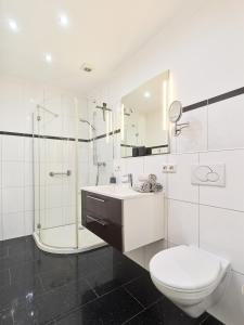 a white bathroom with a toilet and a shower at Ferienweingut Port in Bernkastel-Kues +16 photos
