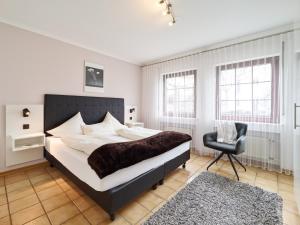 a bedroom with a large bed and a chair at Ferienweingut Port in Bernkastel-Kues