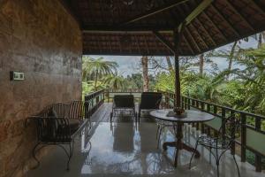 a patio with a table and chairs on a balcony at Alassari Sanctuary in Selemadeg