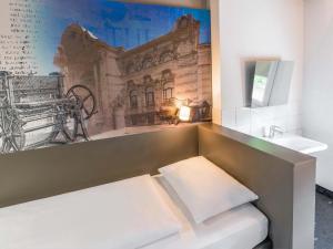 a bathroom with a bench and a painting on the wall at B&B HOTEL Düren in Düren - Eifel