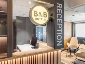 a b b hotel lobby with a sign and chairs at B&B HOTEL Düren in Düren - Eifel