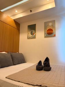a bedroom with a bed with black shoes on the floor at Shell Residences MOA by Jersey in Manila