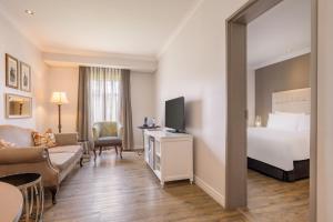 a hotel room with a bed and a living room at Protea Hotel by Marriott Kimberley in Kimberley