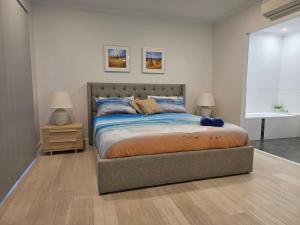 a bedroom with a bed and two lamps and a table at Waves at Jurien, Villa 9-23 Dalton Street in Jurien Bay