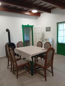 a dining room with a table and chairs at Kaán Károly Kulcsosház in Kisapáti +6 photos