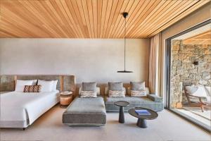 a bedroom with a bed and a couch and a table at Fouquet's Mykonos in Mikonos +58 photos