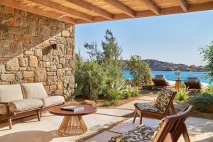 a patio with a couch and chairs and a table at Fouquet's Mykonos in Mikonos