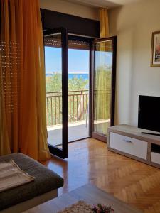 a living room with a view of a balcony at Apartman Dubravko Tribanj in Starigrad