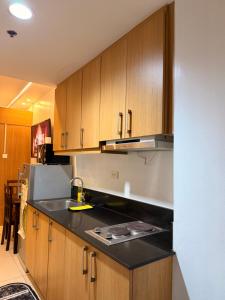 a kitchen with a sink and a counter top at Shell Residences MOA by Jersey in Manila