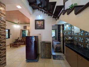 a kitchen with a refrigerator in the middle of a room at Trupti Villa & Cottages-Nagaon- Three BHK Villa in Alibaug