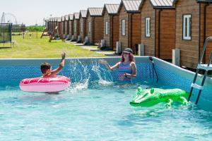 a boy and a girl playing in a swimming pool at DOMKI#ENERGY Zator in Przeciszów