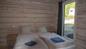 a bed in a wooden room with a window at Sommarbukt Nordlys - Private Arctic Retreat near Tromsø in Tromsø