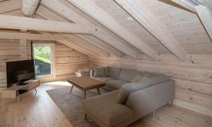 a living room with a couch and a tv at Sommarbukt Nordlys - Private Arctic Retreat near Tromsø in Tromsø