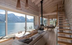 a house with a view of the water and mountains at Sommarbukt Nordlys - Private Arctic Retreat near Tromsø in Tromsø