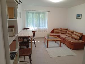 a living room with a couch and a table at Kaán Károly Kulcsosház in Kisapáti