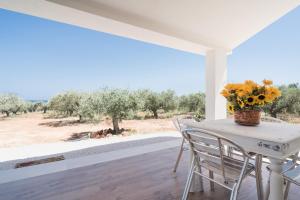 a table with a vase of sunflowers on a porch at Villa Piricone in Orosei