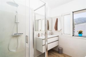 a white bathroom with a shower and a sink at Villa Piricone in Orosei +26 photos