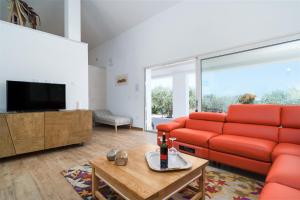 a living room with a red couch and a tv at Villa Piricone in Orosei