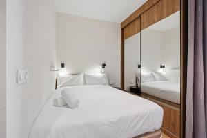 a bedroom with a large white bed and a mirror at Be Casa Barakaldo in Barakaldo +17 photos