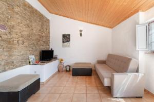 a living room with a couch and a tv at Monte Corte Enchária in São Teotónio