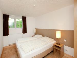 a white bed in a room with a window at Chalet in the Wilder Kaiser ski area in Tyrol in Wörgl