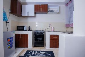 a kitchen with a stove and a refrigerator at Manta Suites Air B&Bs Thika in Thika