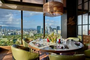 a table in a restaurant with a view of a city at Patina Osaka in Osaka