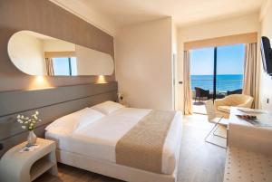 a hotel room with a bed and a view of the ocean at Hotel Le Palme - Premier Resort in Milano Marittima +72 photos