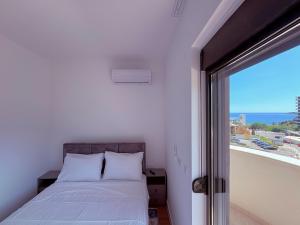 a bedroom with a bed and a view of the ocean at Luxury 2BR Sea View & Garage & Twin Towers Becici in Bečići
