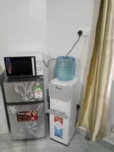 a microwave sitting on top of a refrigerator at Nanyuki Gratia Pad in Nanyuki +1 photo