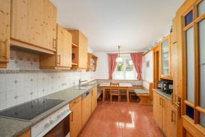 a kitchen with wooden cabinets and a table in it at Appartement Dachsteingasse by Schladming-Appartements in Schladming +12 photos