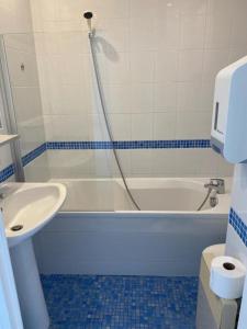 a bathroom with a white tub and a sink at Studio piscine et vue mer in Trévou-Tréguignec +10 photos