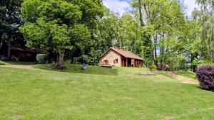 a house in the middle of a grassy yard with a building at Les bouleaux in Cussac