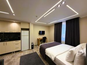 a hotel room with a bed and a tv and a kitchen at Parfe Apart in Trabzon