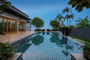 a swimming pool with a view of the ocean at Nariya Bayfront Phuket in Chalong