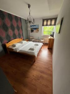a bedroom with a bed and a living room at Dworek na Polance in Wrzosowo