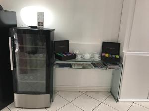 Cette chambre comprend un bureau et un réfrigérateur en verre. dans l'établissement Hôtel Le Capitole, à Toulouse