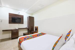 a hotel room with a bed and a tv at FabHotel Anu Grand - Vijayawada in Vijayawāda