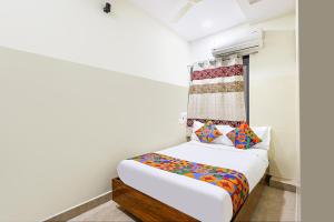 a small bedroom with a bed and a window at FabHotel Anu Grand - Vijayawada in Vijayawāda