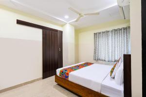 a bedroom with a bed and a ceiling fan at FabHotel Anu Grand - Vijayawada in Vijayawāda