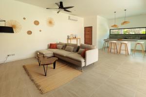 a living room with a couch and a kitchen at Samma Villas - Ruby Villa - 2 BDR & private pool in Ko Phangan