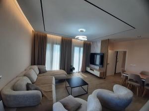 a living room with couches and a flat screen tv at TwinSeas in Draç