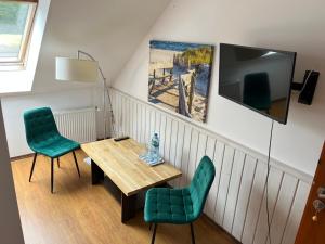 a living room with a table and chairs and a tv at Dworek na Polance in Wrzosowo
